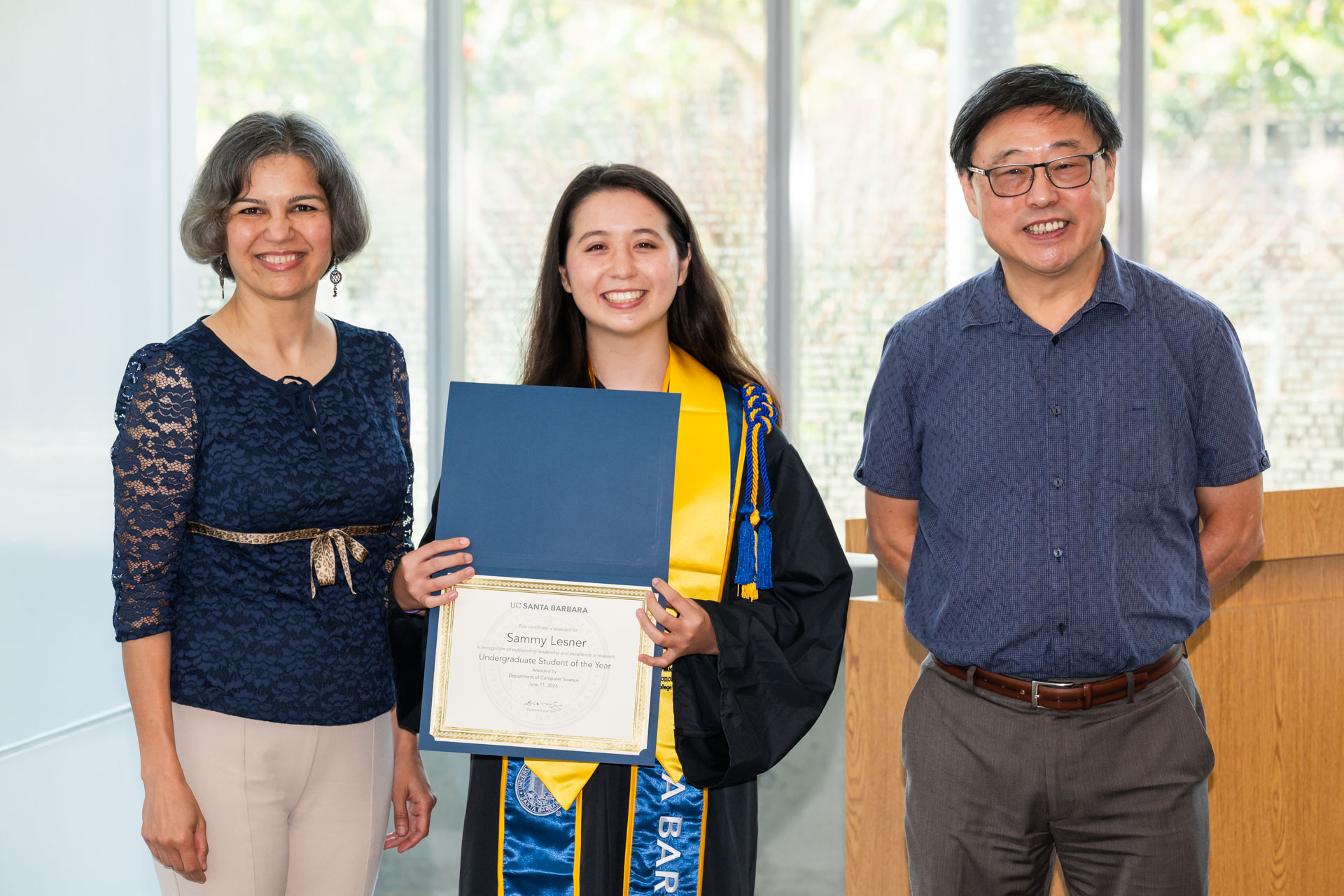 Sammy holding her award certificate, standing with Prof. Majedi and Prof. Su