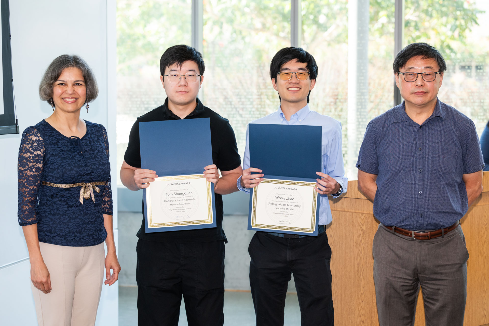 Wong holding his certificate with Prof. Majedi and Prof. Su with another student in the photo